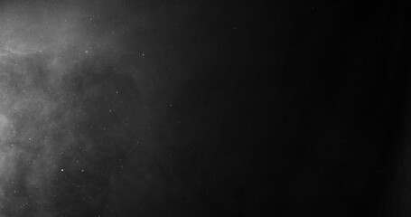 Obraz premium White smoke swirling and dissipating in dark background.