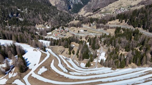 sinuous snowmelt furrows ripple meadow slope marmorera resettled village nestles valley floor beyond winding road climbs forested hillside distant hamlet dots ridge graubunden switzerland julier pass