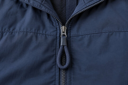Fabric zipper-pull extension on a plain navy jacket