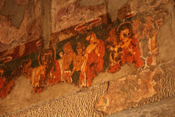 Ajanta, Maharashtra, India, 4 Aug 2026 - Old damaged wall painting showing a group of seated figures in red robes inside the ancient Ajanta cave. © Sambhaji Gaikwad