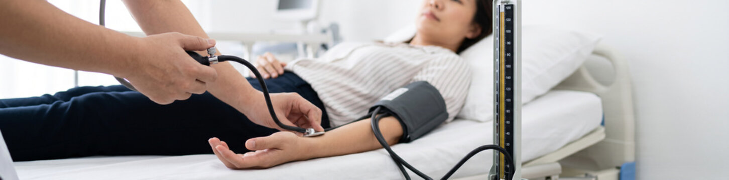 Close-up hands of nurse measuring blood pressure of patient