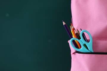 Backpack with stationery against chalkboard, closeup. Space for text © New Africa