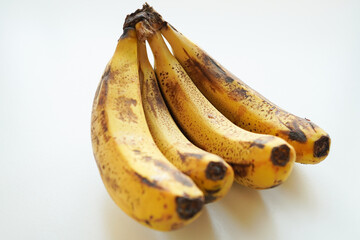 Bunch of overripe bananas with sugar spots on white background © honey