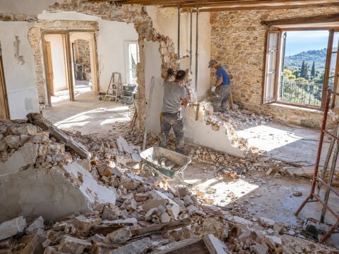 Trabajadores realizan trabajos de demolici&oacute;n en un espacio de construcci&oacute;n en una casa antigua en un &aacute;rea monta&ntilde;osa