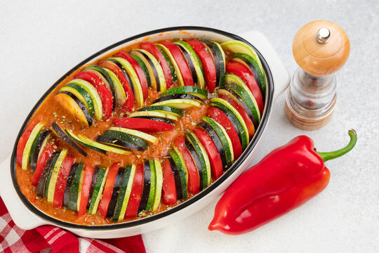 ratatouille of layered vegetables in a baking dish garnished with herbs and spices