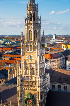 Munich New Town Hall and Marienplatz Aerial View at sunset. Ornate Gothic architecture, distinctive clock tower, surrounding historic buildings, and vibrant city square. Germany