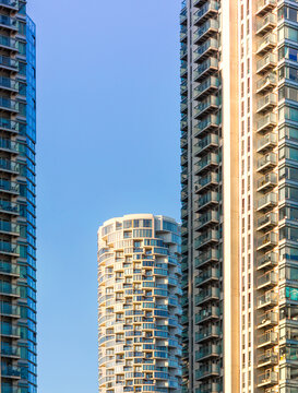 London Canary Wharf Skyscrapers at Sunset. The scene captures the scale and character of London's residential buildings with multiple windows and balconies 