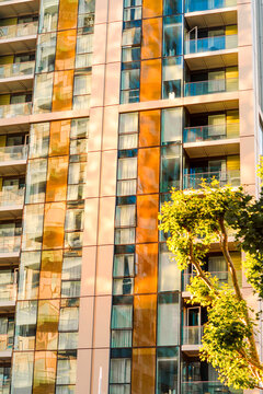 London Canary Wharf Skyscrapers at Sunset. The scene captures the scale and character of London's residential buildings with multiple windows and balconies 