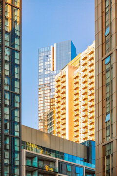 London Canary Wharf Skyscrapers at Sunset. The scene captures the scale and character of London's residential buildings with multiple windows and balconies 