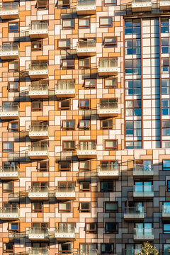London Canary Wharf Skyscrapers at Sunset. The scene captures the scale and character of London's residential buildings with multiple windows and balconies 