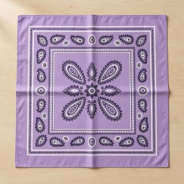 Purple bandana with traditional paisley and floral pattern laid flat on wooden surface