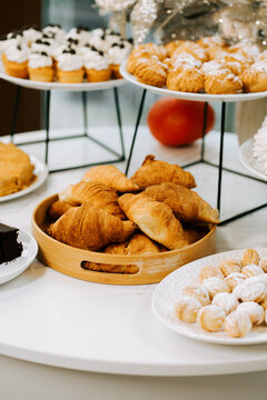 Assorted fresh pastries and cupcakes arranged on serving platters for an afternoon cafe gathering