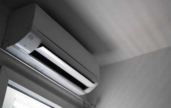 Modern air conditioner on apartment wall.