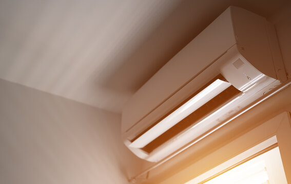 Modern air conditioner on apartment wall.
