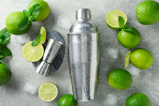 Ingredients for mojito, shaker and jigger on light grey table, flat lay