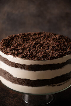 Close view of homemade layered chocolate dirt cake covered with fine cookie crumbs, showing creamy filling and chocolate layers before decoration.