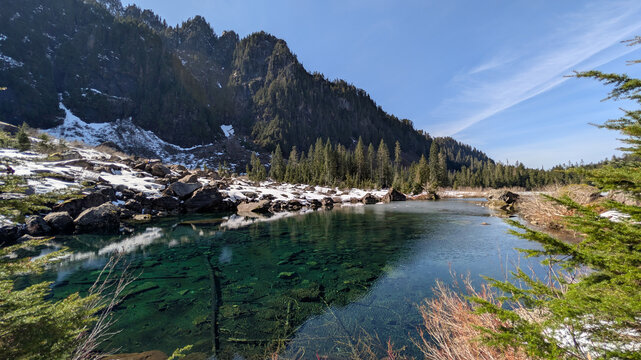 Crystal Clear Waters of Heather Lake Beneath Snow Covered Mountains in Washington State