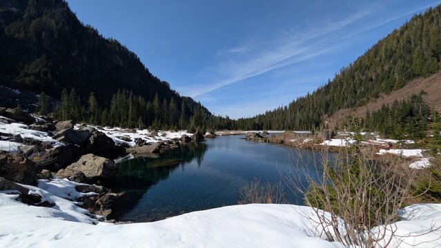 Crystal Clear Heather Lake Surrounded by Snow and Evergreen Forest in Washington State