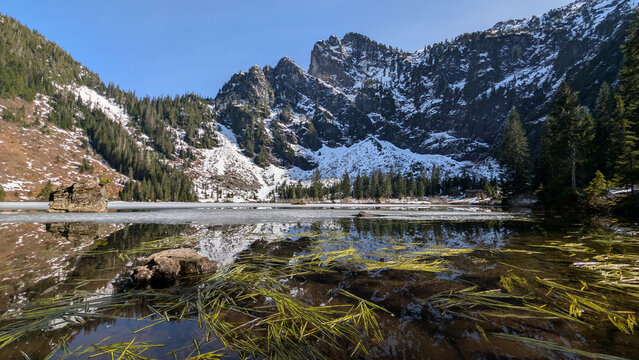 Frozen Heather Lake Beneath Snow Covered Cliffs in Washington State