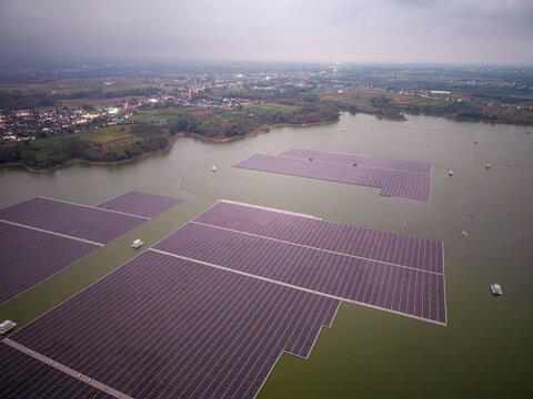 Floating solar panels cover vast lake surfaces. Rows stretch across calm waters at Waduk Karangkates