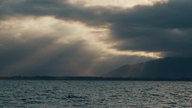 Remote view of the coastline as seen from the moving sailing vessel. Brazilian shore during sunset time as seen from a boat