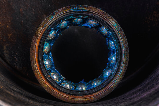 Old industrial ball bearing with grease, raceways and rolling elements, mechanical component, support loads and reduce friction