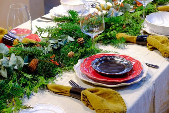 Christmas table setting with greenery and red plates