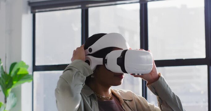 Woman wearing VR headset testing virtual demo in bright office loft, adjusting straps and smiling