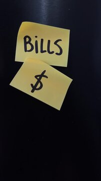 Bills and dollar sign sticky notes on black background vertical