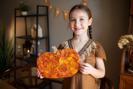 craft for kids. DIY autumn craft from leaves - pumpkin for thanksgiving day. create art for children. happy girl