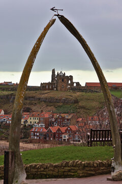 Old real whalebone arch at Whitby, North Yorkshire; historic whaling heritage archway framing Whitby Abbey ruins and St Mary's Church, iconic coastal viewpoint on Yorkshire Coast, England, UK