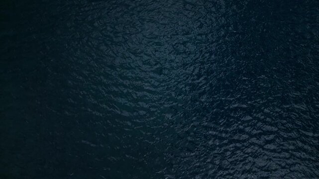 Dark blue water surface with gentle ripples and waves