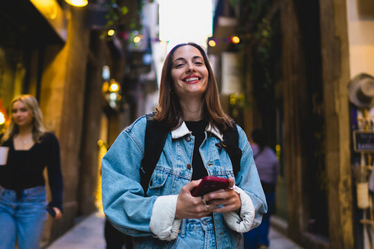 Close up portrait of confident Caucasian female freelancer smiling looking at camera with smartphone, verifying cybersecurity data protection protocols and safe wireless network settings