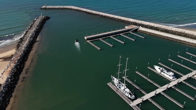 Top view from drone of sailboats and various speed boats in dock. Aerial view of luxure yachts and motorboats moored in a port with clear blue water in summer. Vilamoura, Algarve, Portugal