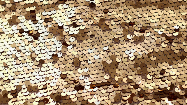 Gold sequins fabric texture background with shiny glitter scales.