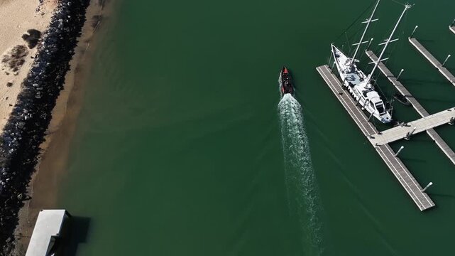 Top view from drone of sailboats and various speed boats in dock. Aerial view of luxure yachts and motorboats moored in a port with clear blue water in summer. Vilamoura, Algarve, Portugal