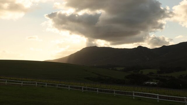shafts of light falling on Klein Mountains and rolling hillside, Stanford, South Africa