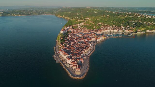 Cinematic aerial side view drone shot of Piran peninsula showcasing the historic old town, Slovenia.