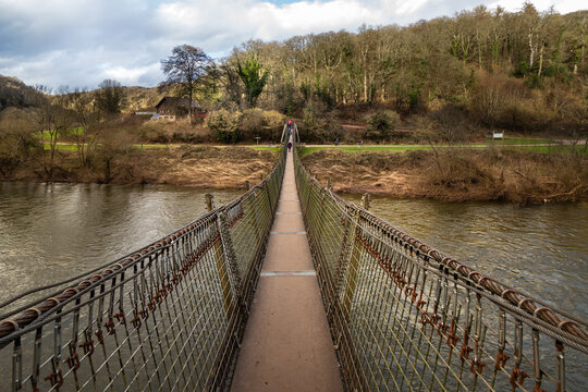 Biblins Rope Bridge crossing the River Wye surrounded by green trees in the Wye Valley woodland landscape