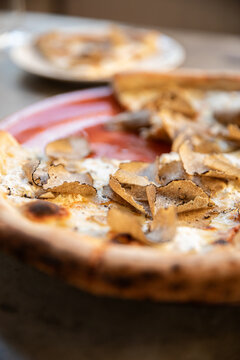 Close-up shot with selective focus and depth of field of wood fired pizza with fresh shaved truffles