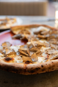 Close-up shot with selective focus and depth of field of wood fired pizza with fresh shaved truffles