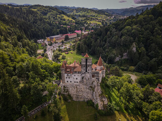 Aerial View of Bran Castle in Romania, surrounded by lush Transylvanian forests © Greggory Zzyzx