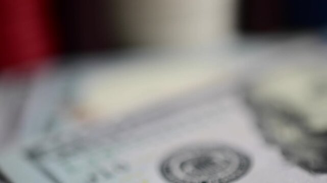 Selective focus video macro cash hundred dollar bills composed with gambling chips, abstract bokeh close up, gambling money finances theme