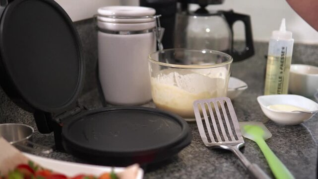 Person pouring pancake batter onto hot griddle