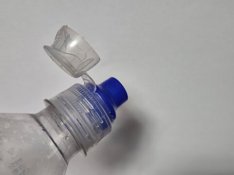 close up of new cap attached to plastic bottle connected to the neck of the bottle by solid tab attached to safety ring they are intended to encourage recycling as part of the fight against litter