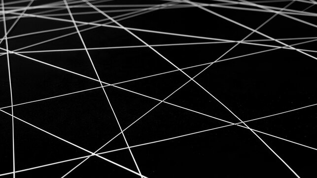 Black and white abstract background with multiple white lines intersecting in a diagonal pattern.
