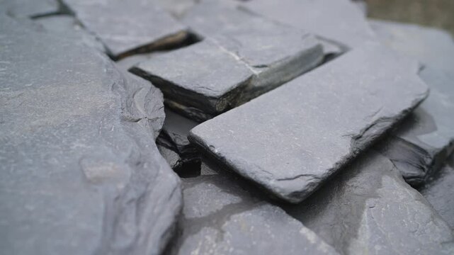 Background of natural stone construction material. Shallow depth of field focuses on layered rock formation. Abstract pattern with cool gray tones for building or geology concepts