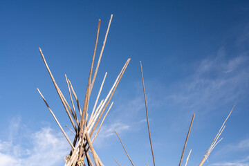 Wooden poles gathered at the tops of tipis © Christian