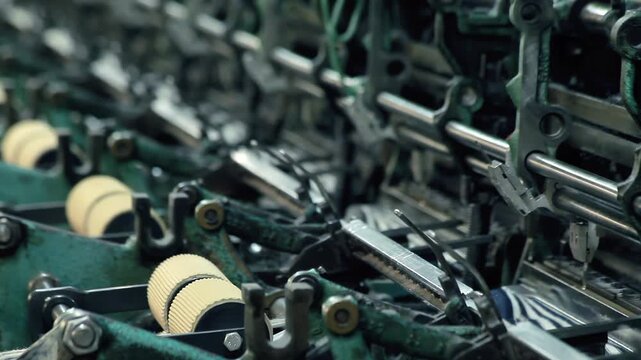 Close up vintage textile loom mechanism. Metal gears levers weaving factory.