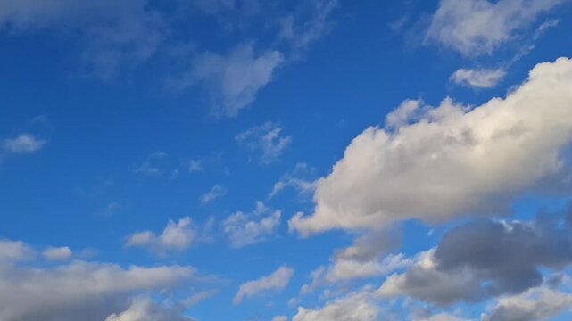 White fluffy clouds moving across the beautiful blue sky on a sunny day, beautiful nature landscape, freedom concept. Timelapse